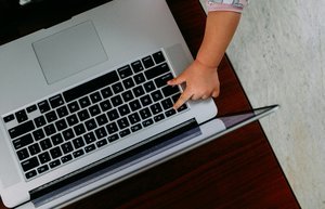 La main d'un bébé sur le clavier d'un ordinateur portable.