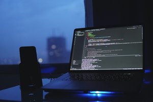 Un ordinateur portable sur un bureau émettant une lumière bleue, créant une ambiance moderne et technologique.