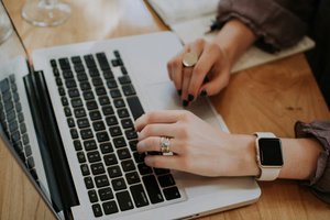 Les mains d'une femme tapant sur le clavier d'un ordinateur portable