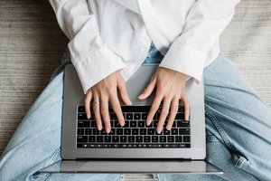 Les mains d'une femme tapant sur le clavier d'un ordinateur portable.